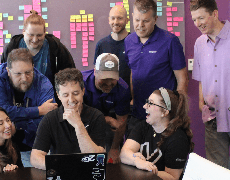 The Next 20 Years - David's Final Thoughts on 20 Moments/20 Years - David and team laughing around a computer screen